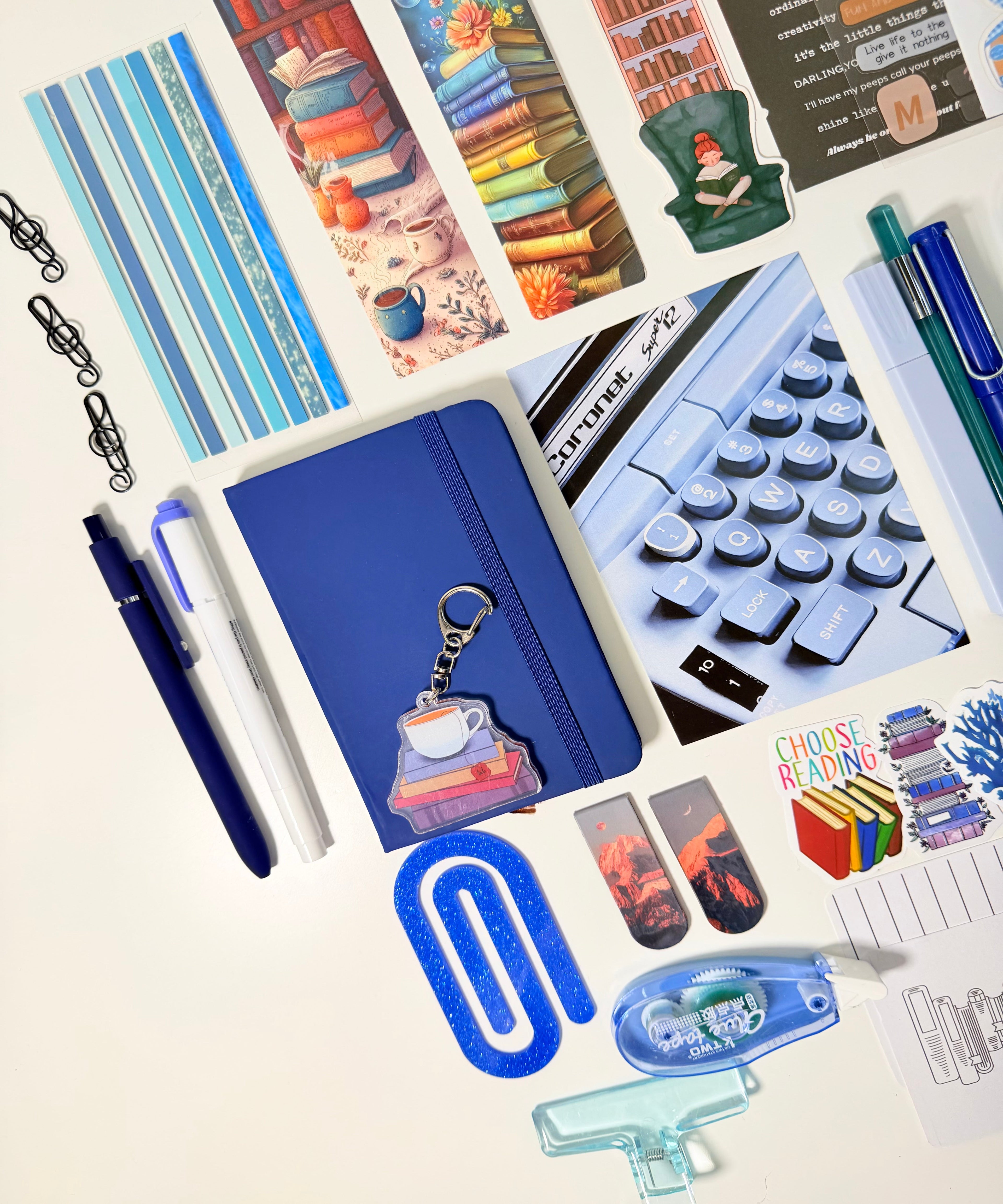 Collection of stationery items including pens, notebooks, and stickers on a white background